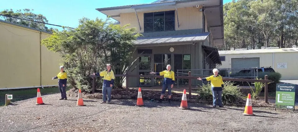 Landcare nursery building with volunteers standing in front and orange traffic cones across the new entrance